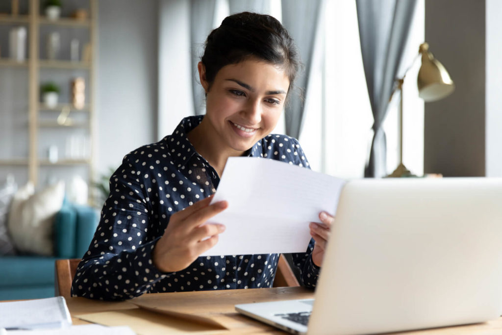 Young woman reviewing financial documents before filing tax deductions and considering whether or not to itemize charitable donations